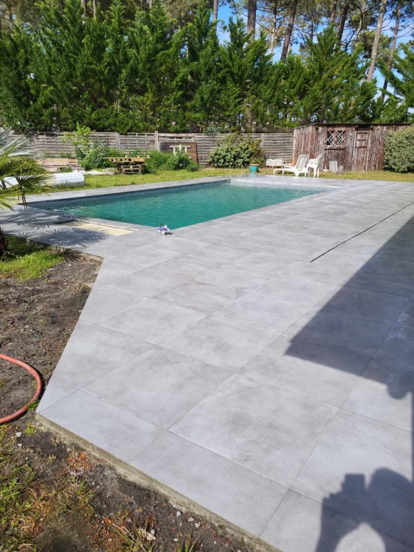 Réalisation d'une terrasse de 90m² autour d'une piscine avec revêtement carrelage à Biscarrosse