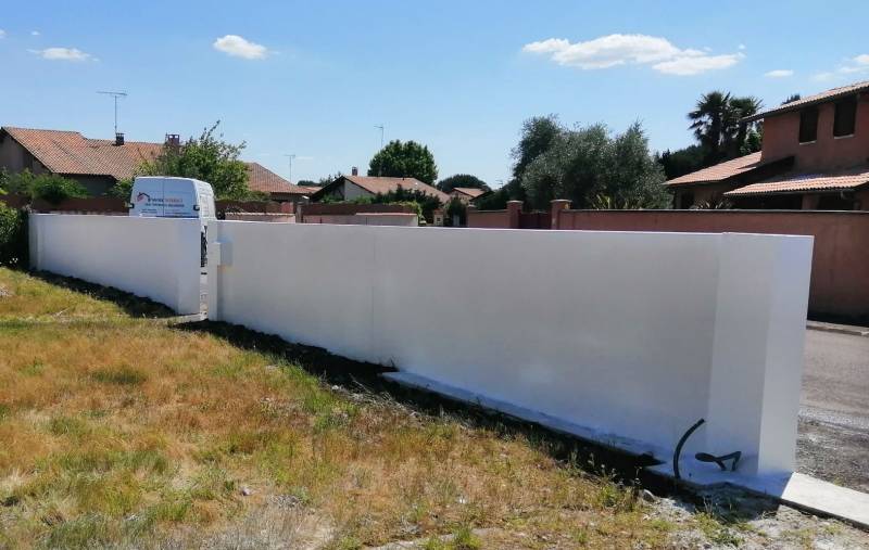 Rehaussement sur mesure d'un mur de clôture en parpaing avec enduit de façade à La Teste-de-Buch