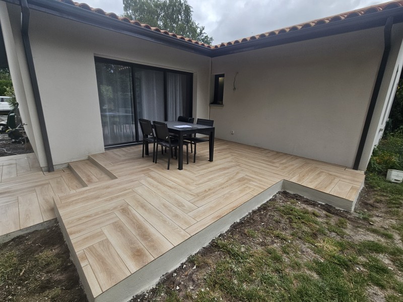 Terrasse en béton avec carrelage extérieur en continuité avec l’intérieur d’un espace situé à Mios