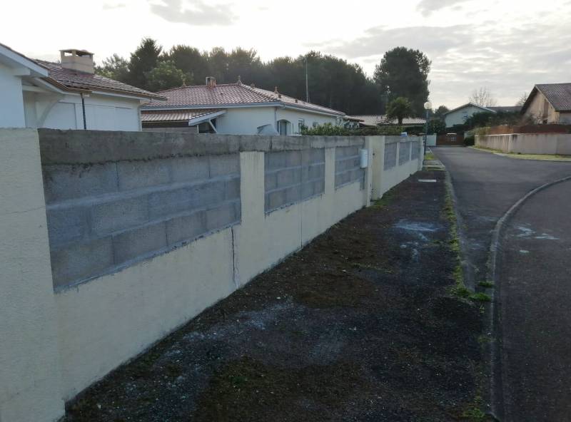 Rehaussement de qualité d'un mur de clôture en parpaing avec enduit de façade à La Teste-de-Buch en Gironde
