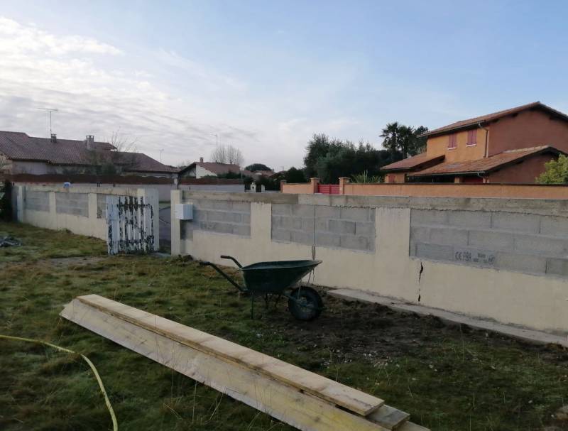 Rehaussement sur mesure d'un mur de clôture en parpaing avec enduit de façade à La Teste-de-Buch en Gironde