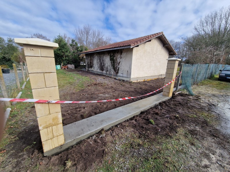 Entrée de portail et d'un trottoir en béton autour d’une maisonnette à Parentis-en-Born